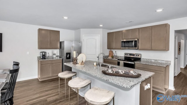 18882 Wicklow Cir, Athens, AL 35613 - kitchen featuring appliances with stainless steel finishes, a sink, dark wood finished floors, baseboards, and a breakfast bar