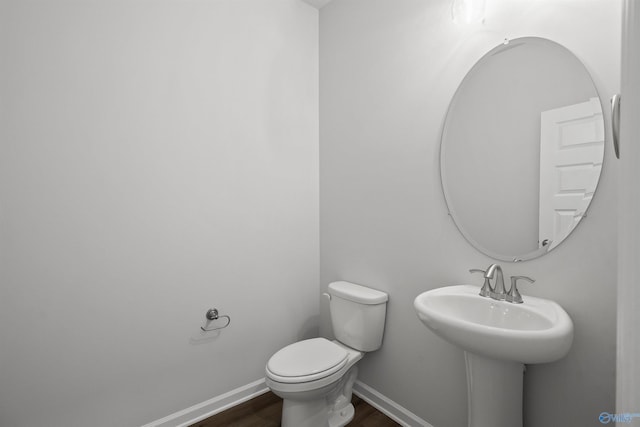 bathroom with hardwood / wood-style flooring, toilet, and sink