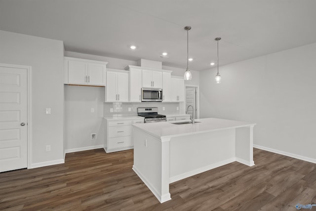 kitchen featuring decorative light fixtures, stainless steel appliances, a center island with sink, and sink