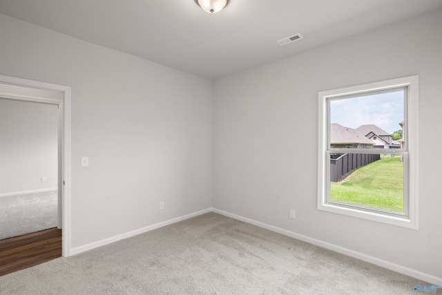 carpeted spare room featuring plenty of natural light