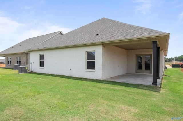 rear view of house with french doors, a patio, central AC unit, and a lawn