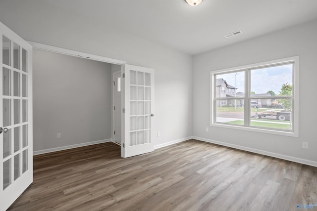 empty room with hardwood / wood-style flooring and french doors