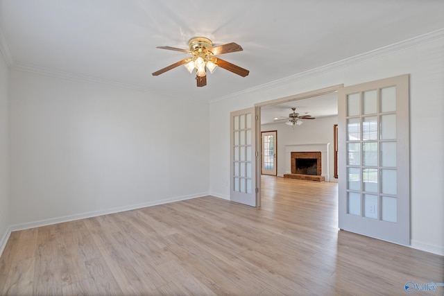 unfurnished living room with a fireplace, french doors, ceiling fan, ornamental molding, and light hardwood / wood-style flooring