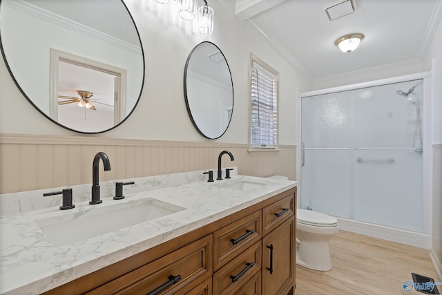 bathroom featuring toilet, wood-type flooring, crown molding, vanity, and an enclosed shower