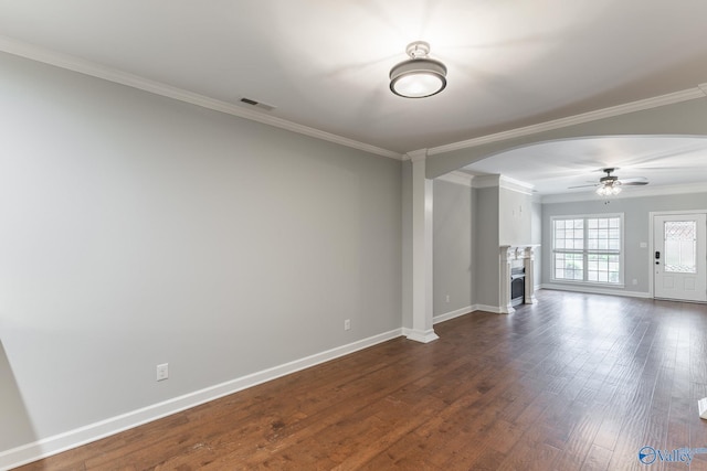 unfurnished living room featuring arched walkways, a ceiling fan, visible vents, and ornamental molding