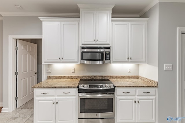 kitchen featuring crown molding, appliances with stainless steel finishes, white cabinets, and light stone countertops