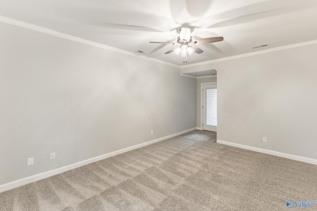 spare room with a ceiling fan, baseboards, ornamental molding, and light carpet