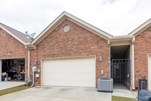 garage featuring central AC unit and concrete driveway