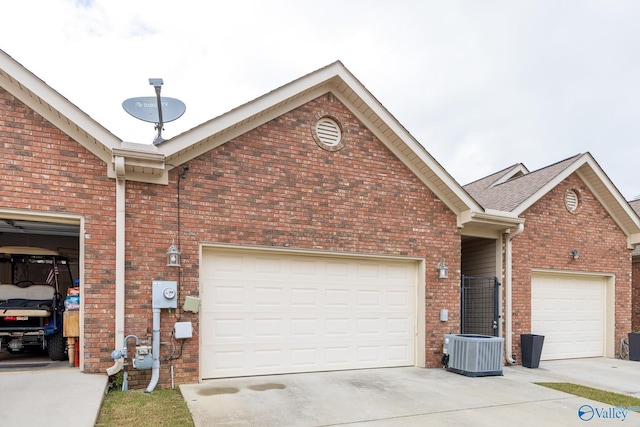 exterior space featuring brick siding, driveway, and cooling unit