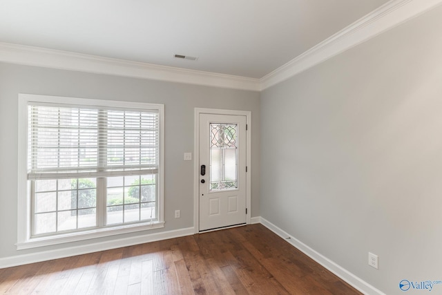 foyer featuring dark wood-style flooring, baseboards, ornamental molding, and a healthy amount of sunlight