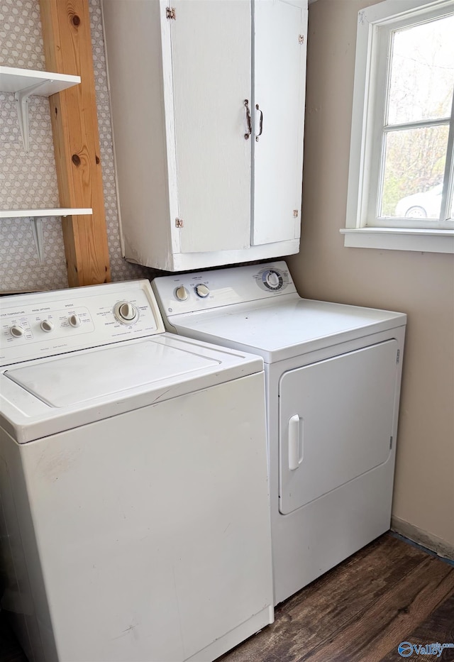 laundry area featuring cabinets, washing machine and dryer, and dark hardwood / wood-style floors