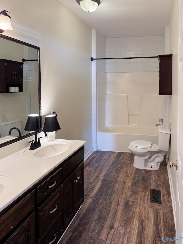 full bathroom featuring hardwood / wood-style flooring, vanity, toilet, and tiled shower / bath combo