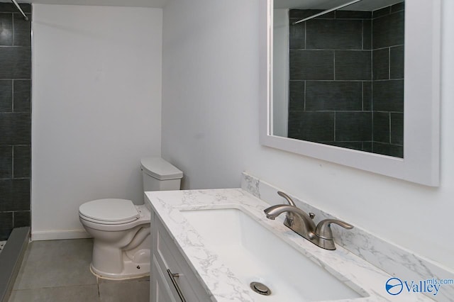 bathroom featuring vanity, toilet, tile patterned floors, and a tile shower