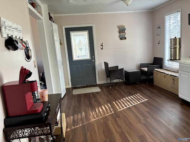 foyer with dark wood-style floors, a textured ceiling, and crown molding