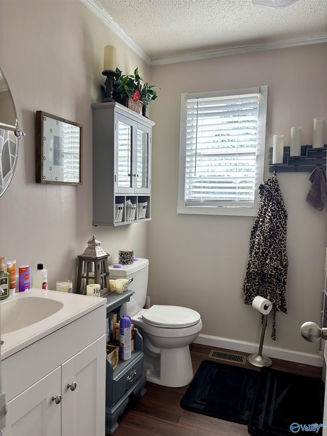 bathroom featuring a textured ceiling, toilet, wood finished floors, vanity, and baseboards