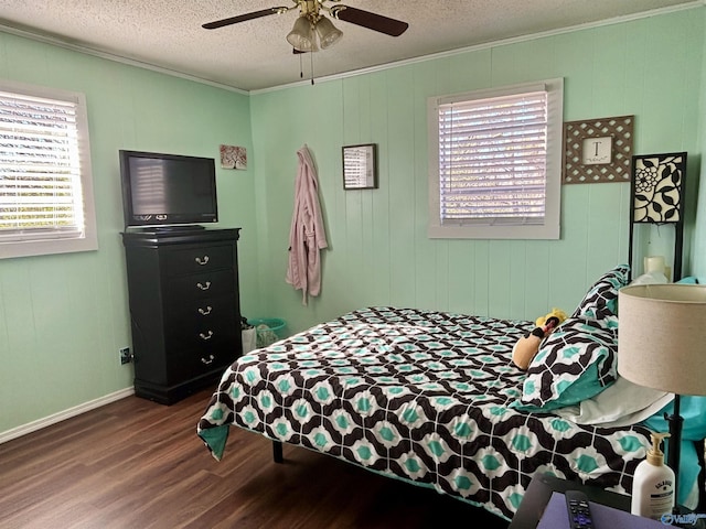 bedroom with ceiling fan, a textured ceiling, ornamental molding, and wood finished floors