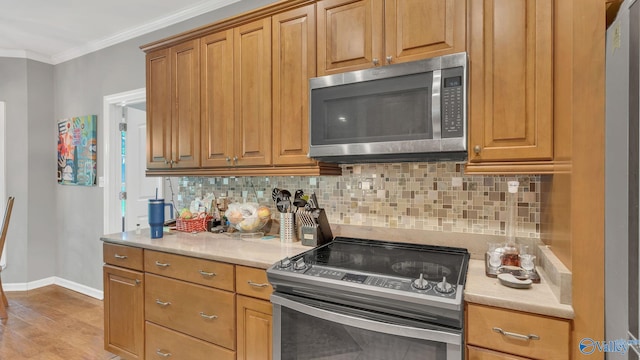 11266 Maggie Lou Dr, Tanner, AL 35671 - kitchen featuring appliances with stainless steel finishes, crown molding, decorative backsplash, baseboards, and light countertops