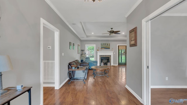 11266 Maggie Lou Dr, Tanner, AL 35671 - living room featuring a fireplace, wood finished floors, ceiling fan, ornamental molding, and a tray ceiling