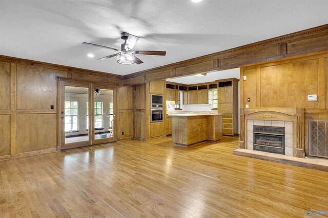 17207 County Road 22, Centre, AL 35960 - kitchen featuring wooden walls, built in microwave, stainless steel oven, ceiling fan, and light wood finished floors