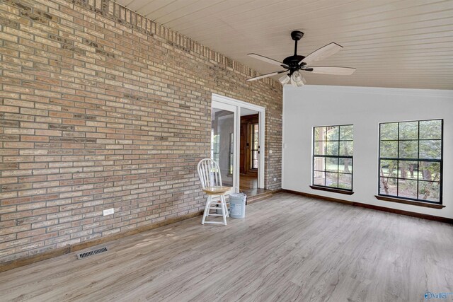 17207 County Road 22, Centre, AL 35960 - unfurnished living room with brick wall, ceiling fan, baseboards, and wood finished floors