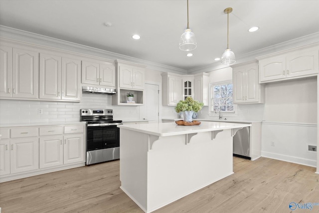 kitchen featuring a center island, exhaust hood, white cabinets, light wood-type flooring, and stainless steel appliances