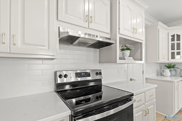 kitchen with white cabinetry, decorative backsplash, stainless steel electric range oven, and crown molding