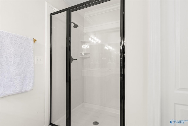 bathroom with a shower with door and crown molding