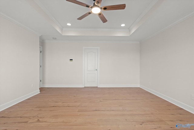 empty room featuring a raised ceiling, ceiling fan, and ornamental molding
