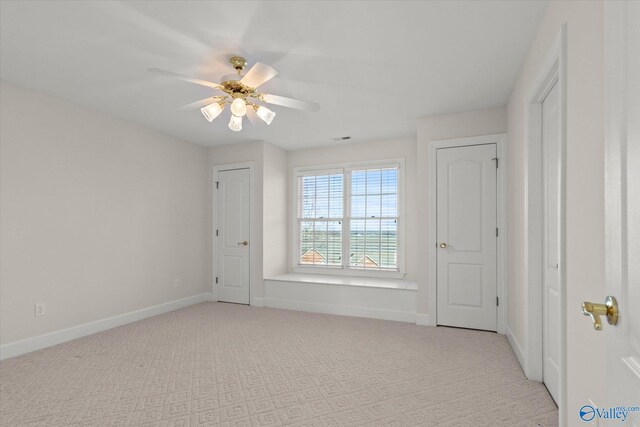 interior space featuring ceiling fan and light colored carpet