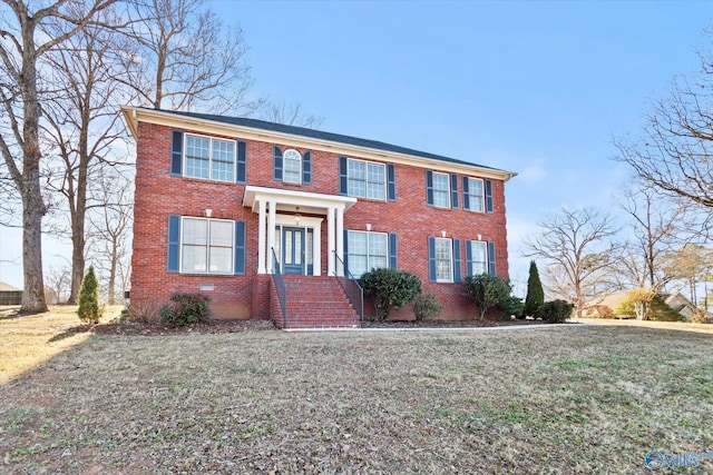 colonial-style house featuring a front lawn