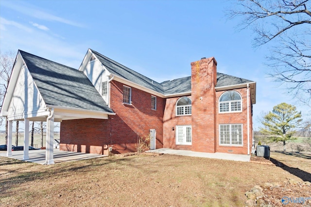 rear view of property with a patio area, a yard, and central AC