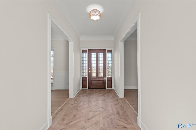 foyer entrance featuring crown molding and light parquet flooring