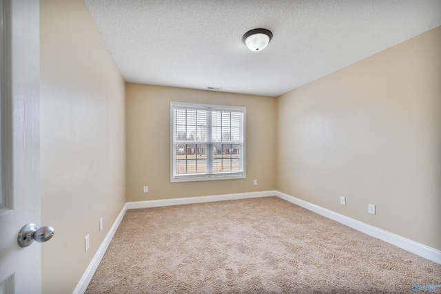 carpeted spare room with a textured ceiling