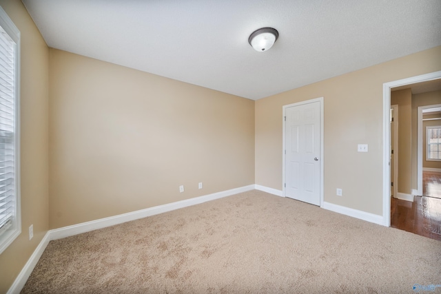 unfurnished bedroom featuring multiple windows and carpet flooring