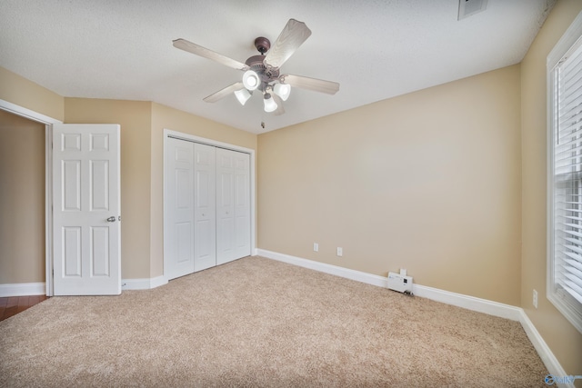 unfurnished bedroom with a closet, ceiling fan, and carpet flooring