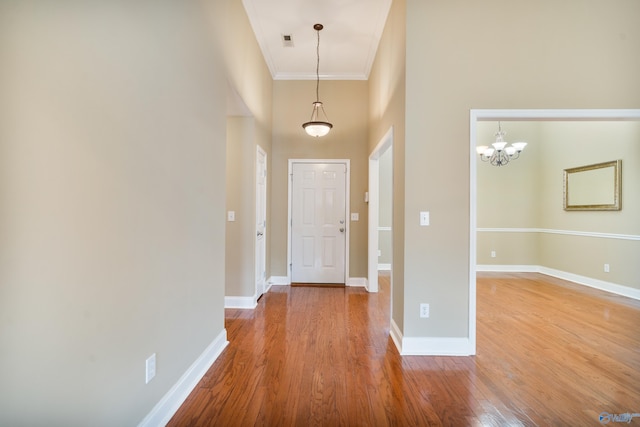 entrance foyer featuring hardwood / wood-style floors, a towering ceiling, and ornamental molding