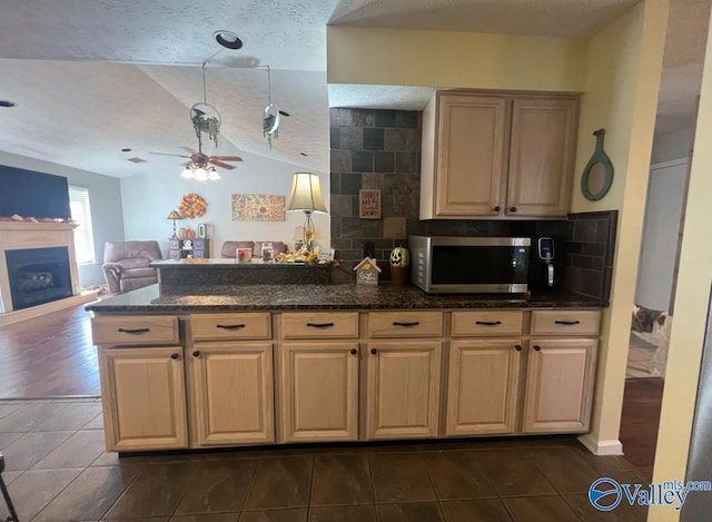 kitchen with ceiling fan, decorative backsplash, dark wood-type flooring, vaulted ceiling, and a textured ceiling