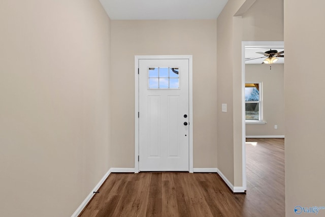 foyer with ceiling fan, baseboards, and dark wood-style floors