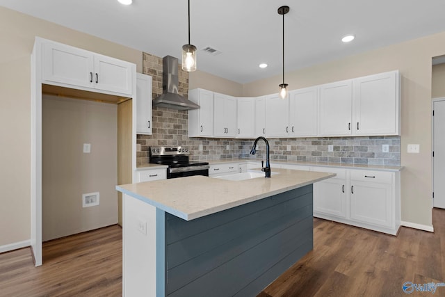 kitchen featuring a sink, white cabinetry, wall chimney exhaust hood, and stainless steel range with electric stovetop