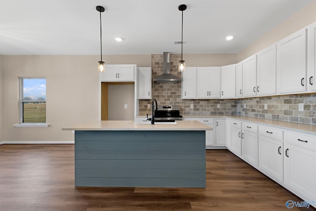 kitchen with a sink, decorative backsplash, wall chimney exhaust hood, and white cabinets