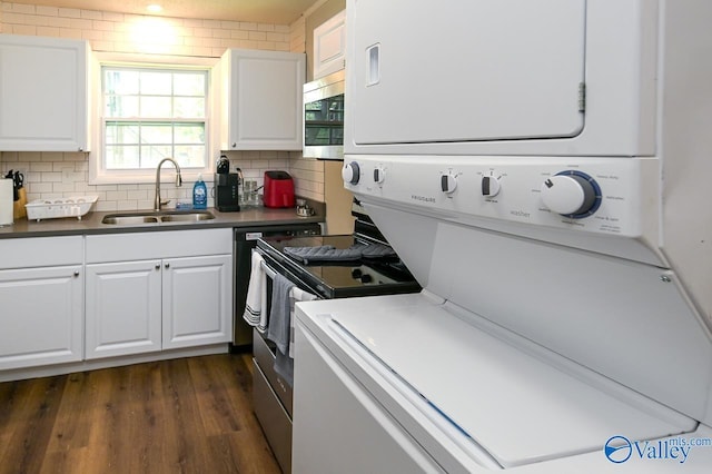 kitchen with stacked washer and clothes dryer, stainless steel microwave, decorative backsplash, white cabinetry, and a sink