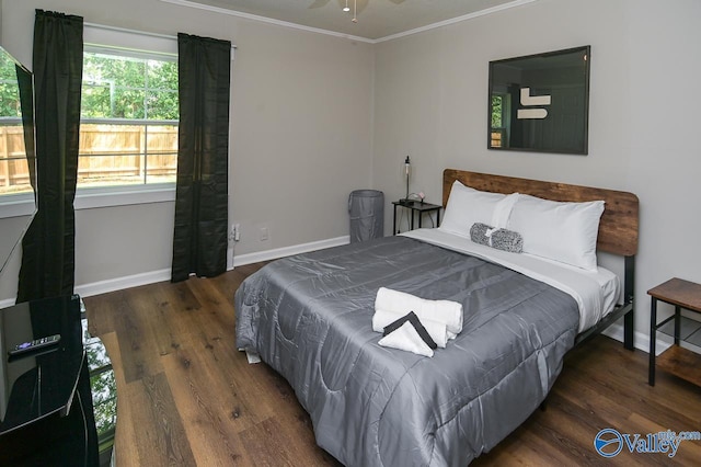 bedroom featuring baseboards, wood finished floors, and crown molding