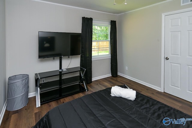 bedroom with baseboards, wood finished floors, visible vents, and crown molding