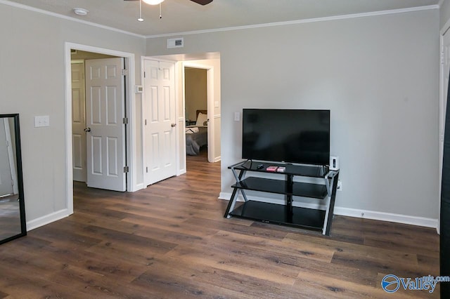 living room featuring visible vents, crown molding, baseboards, and wood finished floors