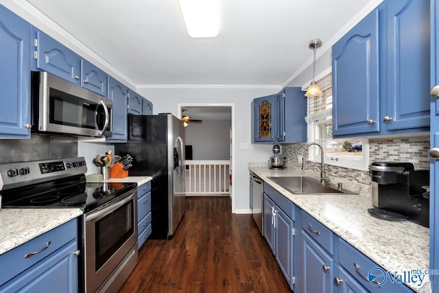 kitchen with blue cabinetry, dark wood-type flooring, light countertops, stainless steel appliances, and a sink