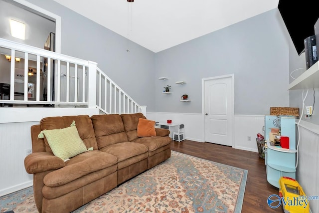 living area with stairs, wood finished floors, and wainscoting