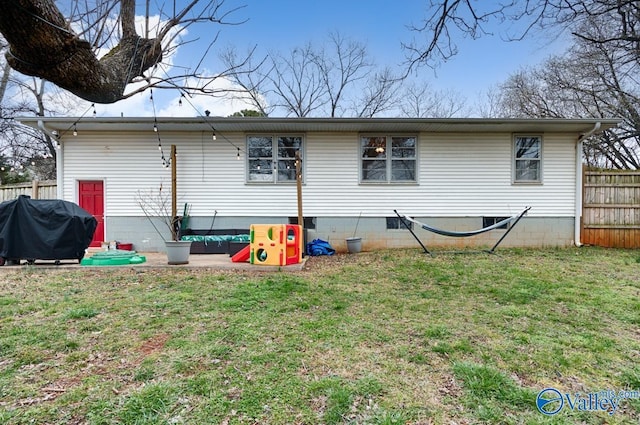 back of house featuring a yard and fence