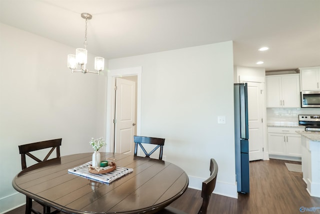 dining space with dark wood-type flooring and a notable chandelier