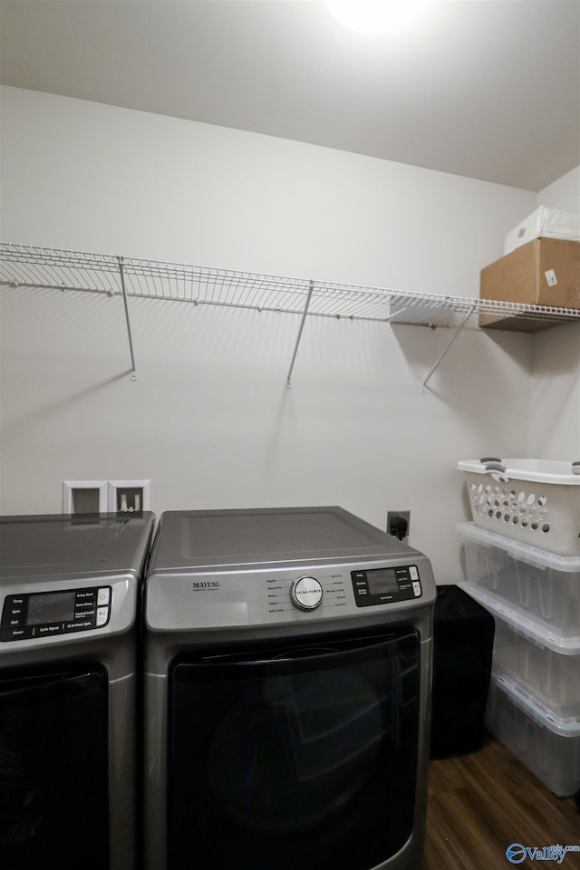 clothes washing area with washing machine and dryer and dark wood-type flooring