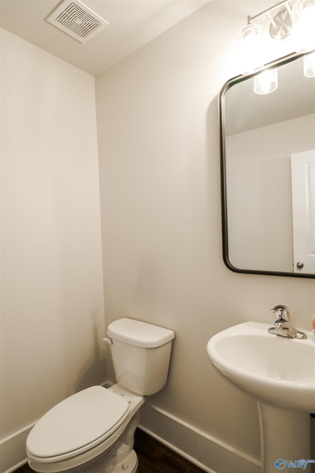 bathroom featuring hardwood / wood-style flooring, sink, and toilet